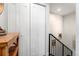 Hallway area with a wooden accent table, decorative mirror, and modern paneling at 2466 S Delaware St # 3, Denver, CO 80223