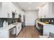 Stylish kitchen with white cabinets, stainless appliances, breakfast bar with leather stools at 2466 S Delaware St # 3, Denver, CO 80223