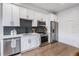 Modern kitchen featuring white cabinetry, stainless steel appliances, and sleek countertops at 2466 S Delaware St # 3, Denver, CO 80223