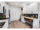 Bright kitchen with white cabinetry, bar seating, and wood plank accent wall at 2466 S Delaware St # 3, Denver, CO 80223