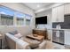 Comfortable living room with a couch, TV and adjacent kitchen area at 2466 S Delaware St # 3, Denver, CO 80223