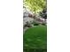 Green grass lawn with mature landscaping, wooden fence, and a rock garden at 4501 Whitehall Ln, Highlands Ranch, CO 80126