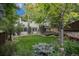 Spacious backyard with a manicured lawn, mature trees, and a wooden deck at 4501 Whitehall Ln, Highlands Ranch, CO 80126