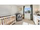 Bright Bedroom featuring a baby crib, chair, and natural light at 4501 Whitehall Ln, Highlands Ranch, CO 80126