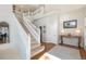 Spacious foyer with hardwood floors, staircase with white banister, console table and neutral colored walls at 4501 Whitehall Ln, Highlands Ranch, CO 80126