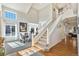 Bright foyer featuring soaring ceilings, staircase with white banister, hardwood floors and large sunlit windows at 4501 Whitehall Ln, Highlands Ranch, CO 80126