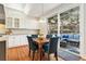 Eat-in kitchen with a wooden table, white cabinets, hardwood floors and sliding doors leading to an outdoor deck at 4501 Whitehall Ln, Highlands Ranch, CO 80126