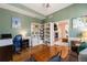 Stylish home office adjacent to the living room featuring ample shelving and comfortable furnishings at 4501 Whitehall Ln, Highlands Ranch, CO 80126