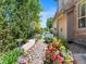 Landscaped backyard with a stone walkway, mature trees, and colorful flower beds at 13645 Osage Ct, Broomfield, CO 80023