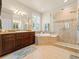Well-lit bathroom features a soaking tub, walk-in shower, and dual vanity at 13645 Osage Ct, Broomfield, CO 80023