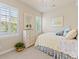 Bright bedroom with a window, shutter, dresser, mirror, and bed with decorative pillows and a blue floral pattern at 13645 Osage Ct, Broomfield, CO 80023