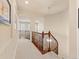 Bright upstairs hallway with a carpet runner, wood railing, arched doorways, and decorative hanging light at 13645 Osage Ct, Broomfield, CO 80023