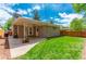 Backyard featuring covered patio area, green lawn, and wooden privacy fence at 3098 S Vine St, Denver, CO 80210