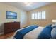 Serene bedroom with hardwood floors, a large window with plantation shutters, and a walk-in closet at 3098 S Vine St, Denver, CO 80210