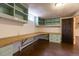 Office featuring built-in desk, custom shelves and cabinets, overhead light, and hardwood floors at 3098 S Vine St, Denver, CO 80210