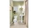 A traditional half-bathroom with tile flooring, a toilet, and a pedestal sink with decorative fixtures at 457 Black Feather Loop # 703, Castle Rock, CO 80104