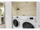 Laundry room features a front-loading washer and dryer with a wire shelf above for extra storage at 457 Black Feather Loop # 703, Castle Rock, CO 80104