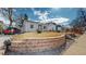 Exterior view featuring a well-manicured lawn, brick retaining wall, and white siding at 4154 Depew St, Denver, CO 80212