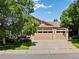 Charming home exterior featuring a three car garage and beautiful landscaping on sunny day at 885 Sage Sparrow Cir, Highlands Ranch, CO 80129