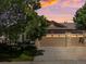 Charming home exterior featuring a three car garage and beautiful landscaping at sunset at 885 Sage Sparrow Cir, Highlands Ranch, CO 80129