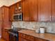 Beautiful kitchen with updated appliances, granite countertops, and cherry wood cabinets at 885 Sage Sparrow Cir, Highlands Ranch, CO 80129