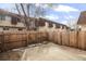 Backyard with tall wood fence enclosing lawn area, covered object, and construction materials at 7755 E Quincy Ave # T80, Denver, CO 80237
