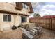 Backyard with tall wood fence, covered object, patio and stacked construction materials at 7755 E Quincy Ave # T80, Denver, CO 80237