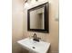 Cozy powder room with pedestal sink, dark wood framed mirror, and attractive bronze faucet at 7755 E Quincy Ave # T80, Denver, CO 80237