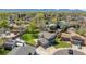 Aerial view of a home in a suburban neighborhood with mature trees, lush lawns, and mountain views at 7367 Coors St, Arvada, CO 80005