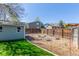 Fenced backyard with garden beds, lush lawn, shed, and the home's exterior, perfect for gardening enthusiasts at 7367 Coors St, Arvada, CO 80005