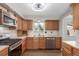 The kitchen features wood cabinets, stainless steel appliances, a window, and lots of counter space at 7367 Coors St, Arvada, CO 80005