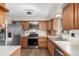 Kitchen boasts wood cabinets, stainless steel appliances, and wood laminate flooring at 7367 Coors St, Arvada, CO 80005