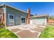 A backyard patio with sliding glass doors, a brick chimney, and access to a well-maintained lawn at 7367 Coors St, Arvada, CO 80005