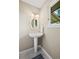 Charming powder room featuring a pedestal sink with decorative mirror and window at 7409 Mount Meeker Rd, Longmont, CO 80503