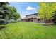 Two-story home exterior showcasing a well-kept lawn, mature trees, and a covered patio for outdoor enjoyment at 7409 Mount Meeker Rd, Longmont, CO 80503