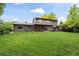 Back exterior view of a two-story home featuring a well-manicured lawn and covered patio at 7409 Mount Meeker Rd, Longmont, CO 80503