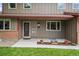 Inviting front entrance with decorative glass door, flanked by colorful flowerpots and lush green lawn at 7409 Mount Meeker Rd, Longmont, CO 80503
