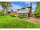 A large manicured backyard features the back of the house, a brick chimney and a sunroom at 12355 E Arkansas Pl, Aurora, CO 80012