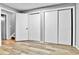 Bedroom with wood-look floors, closet with sliding doors, and updated paint at 12355 E Arkansas Pl, Aurora, CO 80012