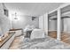 Basement bedroom with white painted brick, wood-look floors, and modern chandelier at 12355 E Arkansas Pl, Aurora, CO 80012