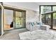 Bright sunroom featuring sliding glass doors, brick accent wall, and a cozy sectional sofa at 12355 E Arkansas Pl, Aurora, CO 80012