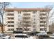 Stately building with multiple balconies, mature trees, and street-level parking at 1365 Columbine St # 301, Denver, CO 80206