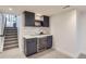 Basement bar featuring cabinets, shelving, beverage cooler, and modern backsplash at 7998 S Wabash Ct, Centennial, CO 80112