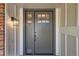 Close-up of a modern front door featuring sidelights and a stylish light fixture at 7998 S Wabash Ct, Centennial, CO 80112