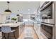 Kitchen with quartz counters, stainless appliances, stylish pendant lighting, and island seating at 7998 S Wabash Ct, Centennial, CO 80112