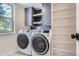Laundry room featuring a modern washer and dryer, and custom cabinets at 7998 S Wabash Ct, Centennial, CO 80112