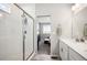 Bathroom featuring a walk-in shower with white tiled walls and a glimpse of the main bedroom at 8346 Mount Kataka St, Littleton, CO 80125
