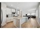 Open kitchen with stainless appliances and island seamlessly flows into the dining and living areas at 8346 Mount Kataka St, Littleton, CO 80125