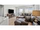 Comfortable living room with a plush leather sofa, TV on media center, and sliding glass doors to the outside at 8346 Mount Kataka St, Littleton, CO 80125