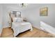 Serene bedroom with wood floors, white bedding, and a black and gold mid-century modern light fixture at 5211 W 4Th Ave # C, Lakewood, CO 80226